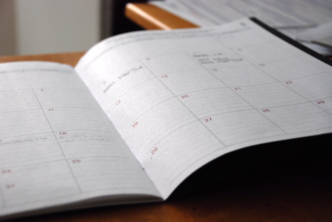 Monthly planner on wooden desk — representing the seven-year accreditation cycle and the phases between visits