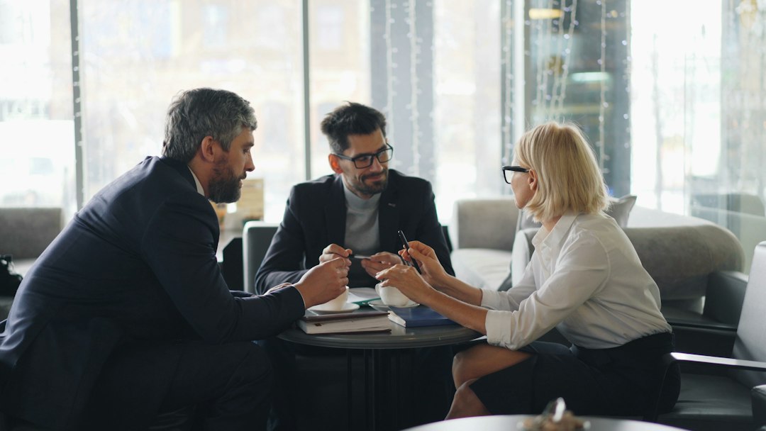 Three program stakeholders in discussion at a small round table