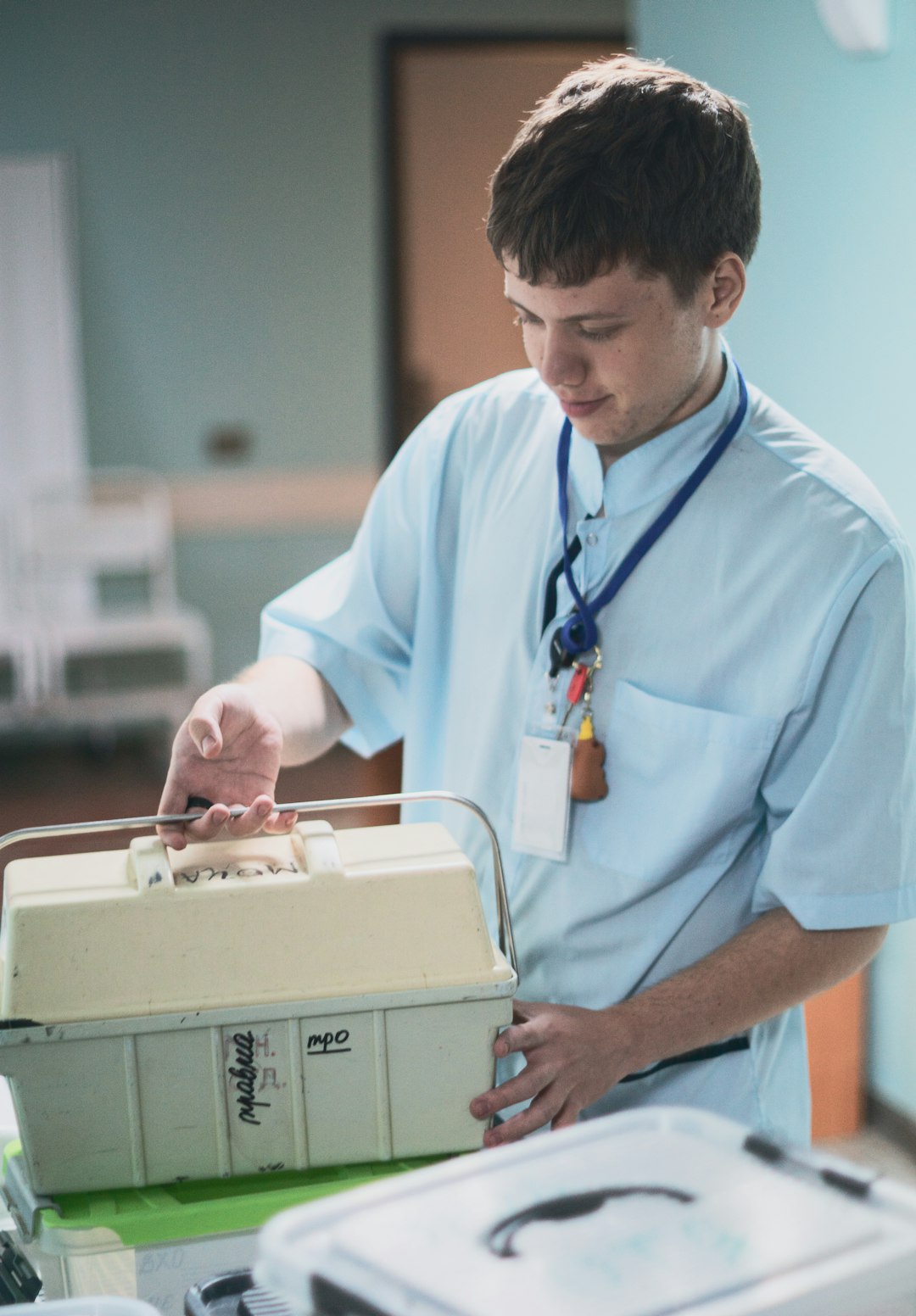 A nursing student preparing simulation equipment in a skills lab