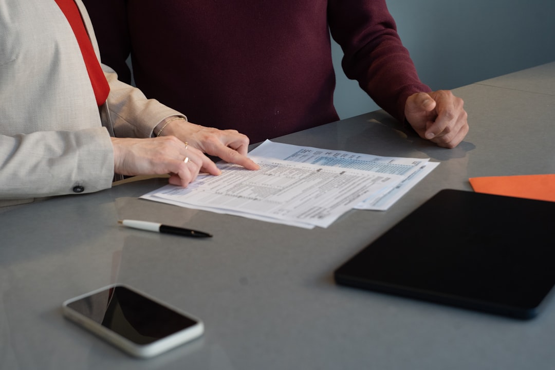 Two accreditation team members reviewing evidence documents together at a table