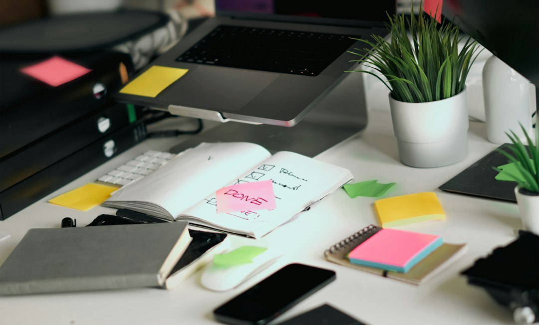 A tidy office desk with an open notebook, post-it notes and laptop, the everyday rhythm of continuous evidence collection