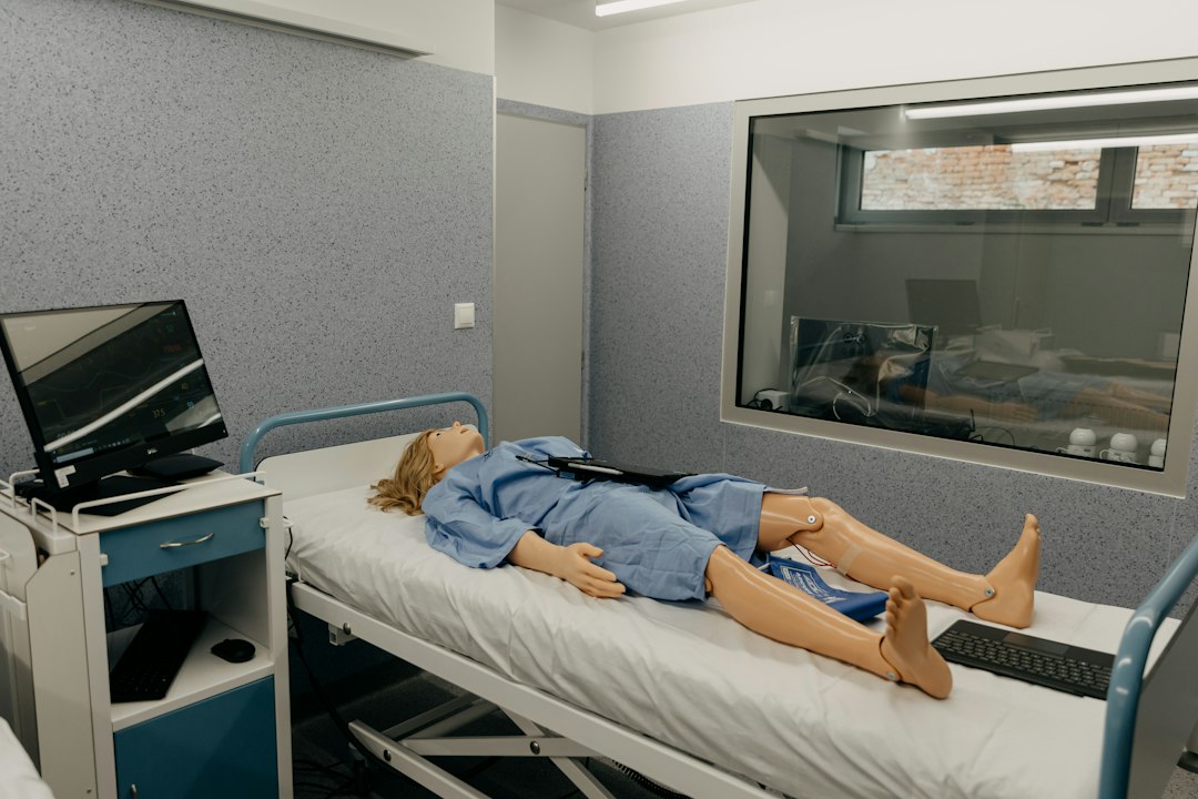 A telemedicine simulation room with a patient mannequin and observation window