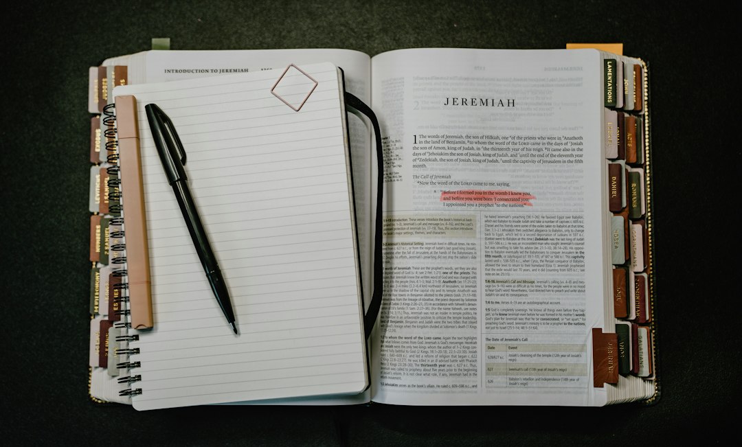 An open notebook with a pen beside a reference book, used to declare competence levels before mapping courses