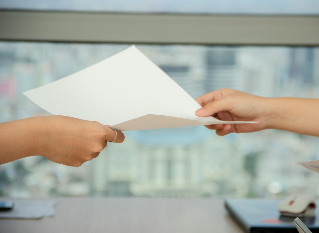 Two colleagues handing over a document in a handover