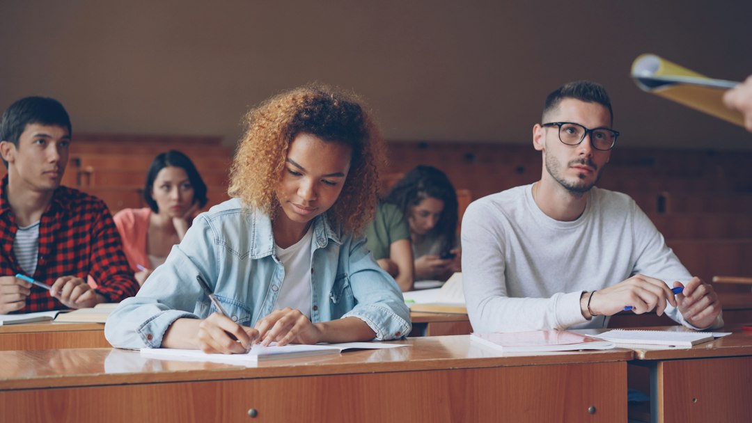 Students taking notes in a lecture hall