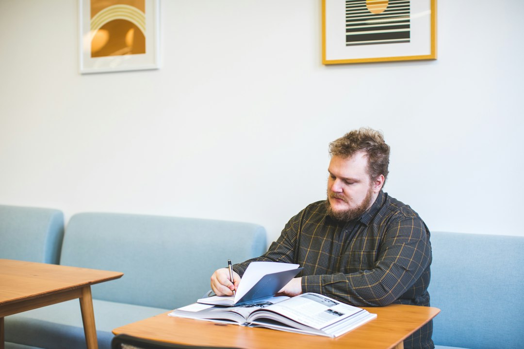 Professor writing in a notebook in a bright open office, illustrating how a connected evidence system changes the equation