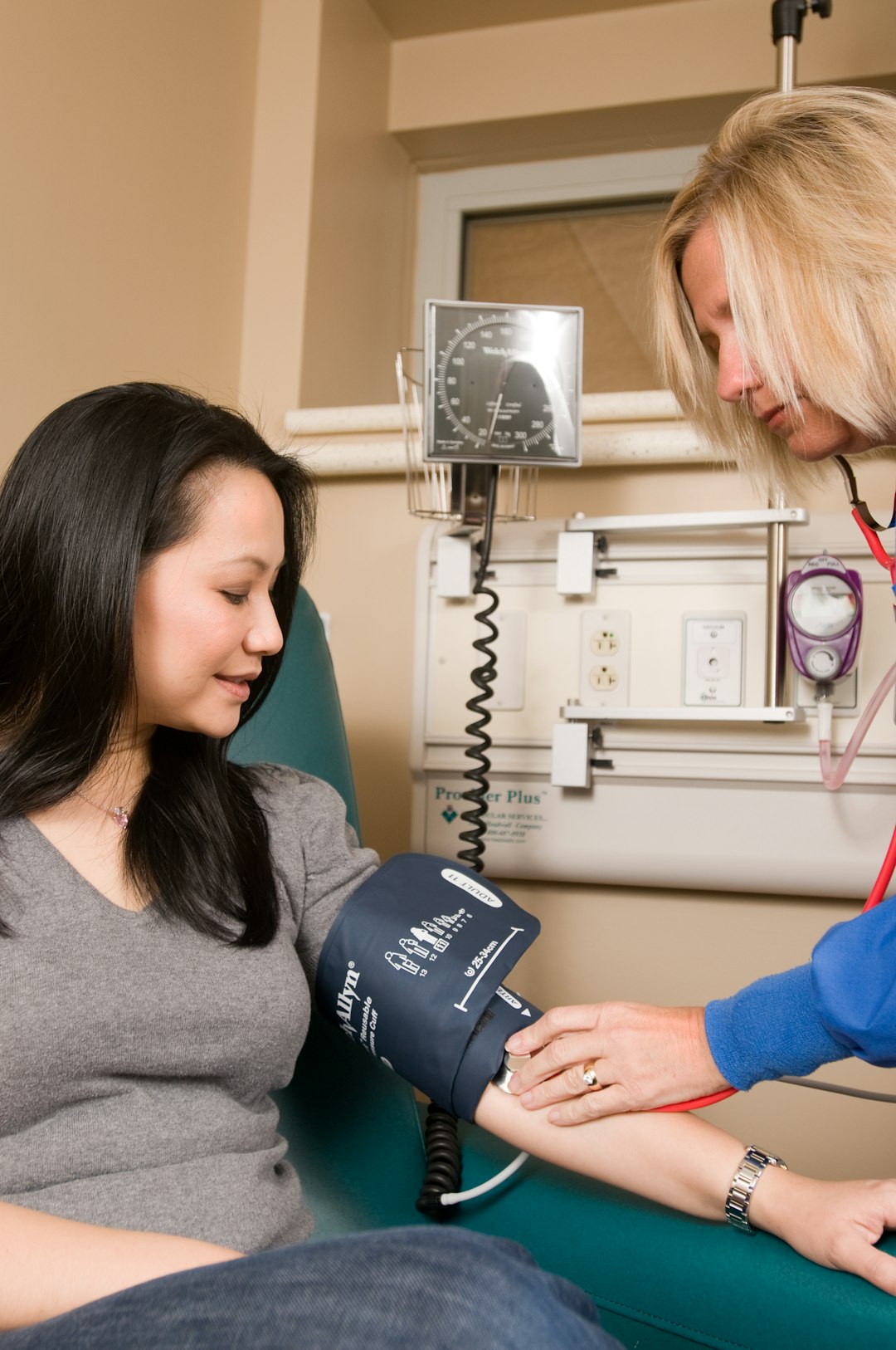 A nurse taking a patient's blood pressure in a clinical setting